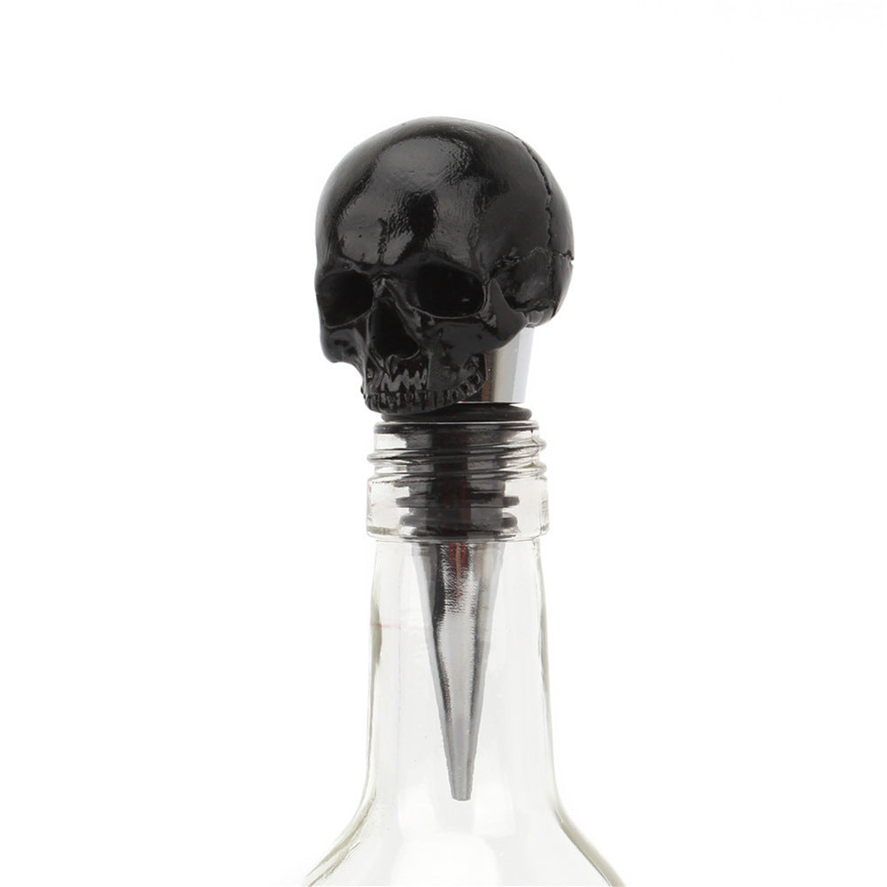 Black skull bottle stopper with stainless steel spike, front view on wine bottle