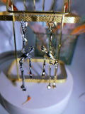 Pair of articulated skeleton dangle earrings on a display rack