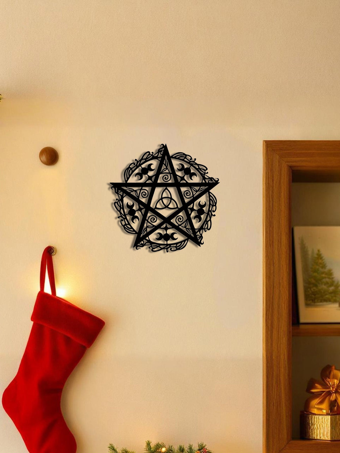 The Wyrdmark triple moon pentagram wall sculpture hung on a wall near a doorway