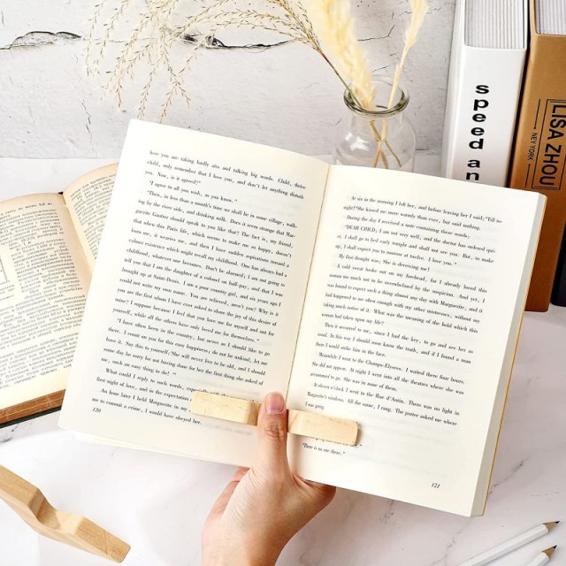 Wooden thumb page holder keeping a book open one-handed