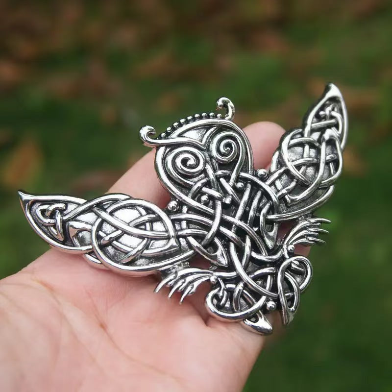 Antique silver Celtic knotwork owl hair fork held in hand, showing true scale