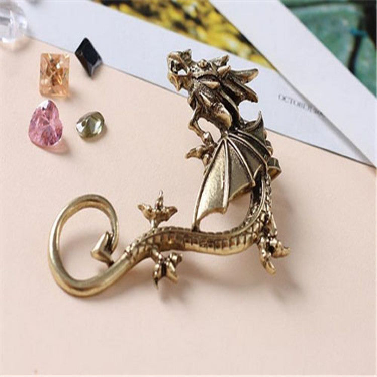 Dragon ear cuff shown flat in antique bronze finish, single piece with spread wing and curling tail