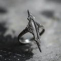 Antiqued silver double-thorn gothic ring, front view on dark stone