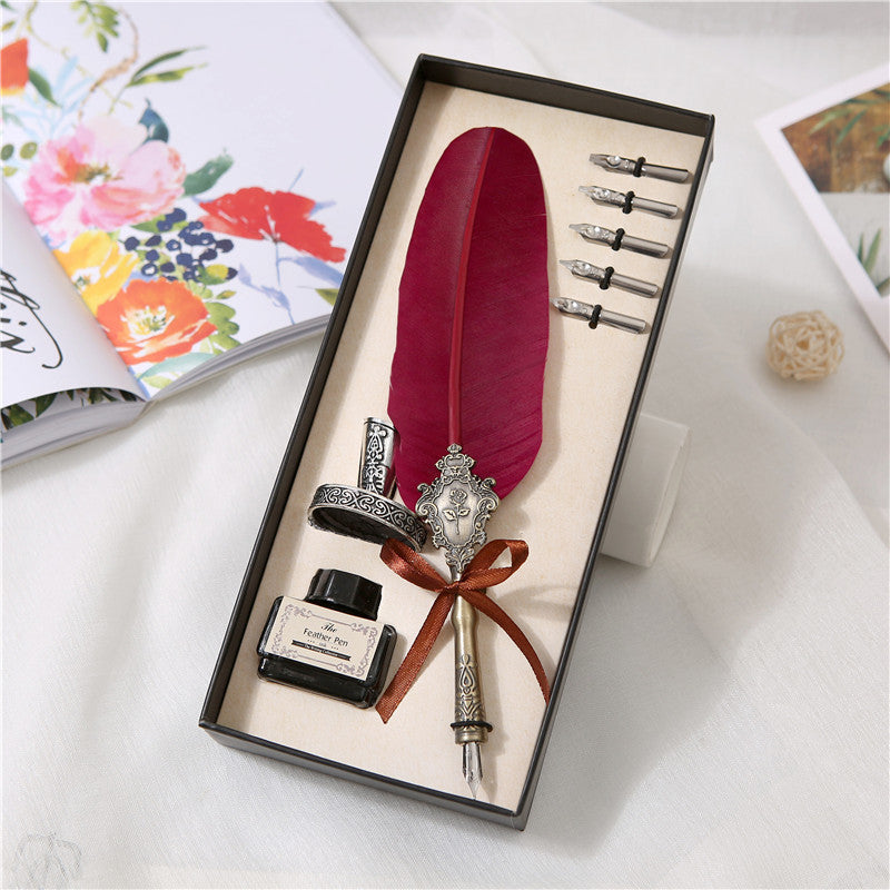 Black feather quill pen and ink writing set in ribbon-tied presentation box with five spare nibs