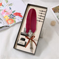 Black feather quill pen and ink writing set in ribbon-tied presentation box with five spare nibs