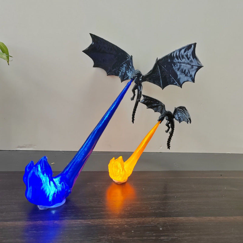 Two black 3D-printed dragons suspended on glowing blue and orange LED flame columns on a dark wood shelf