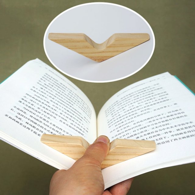 Carved wood thumb ring page spreader on open book