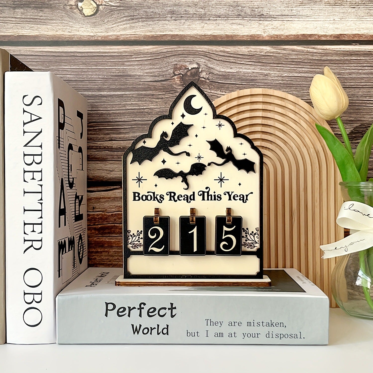 Gothic arch reading tracker standing on a shelf beside books, counter reading 215