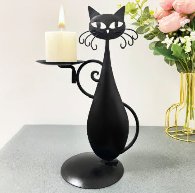 Witchy black cat candlestick on a mantel with candle burning