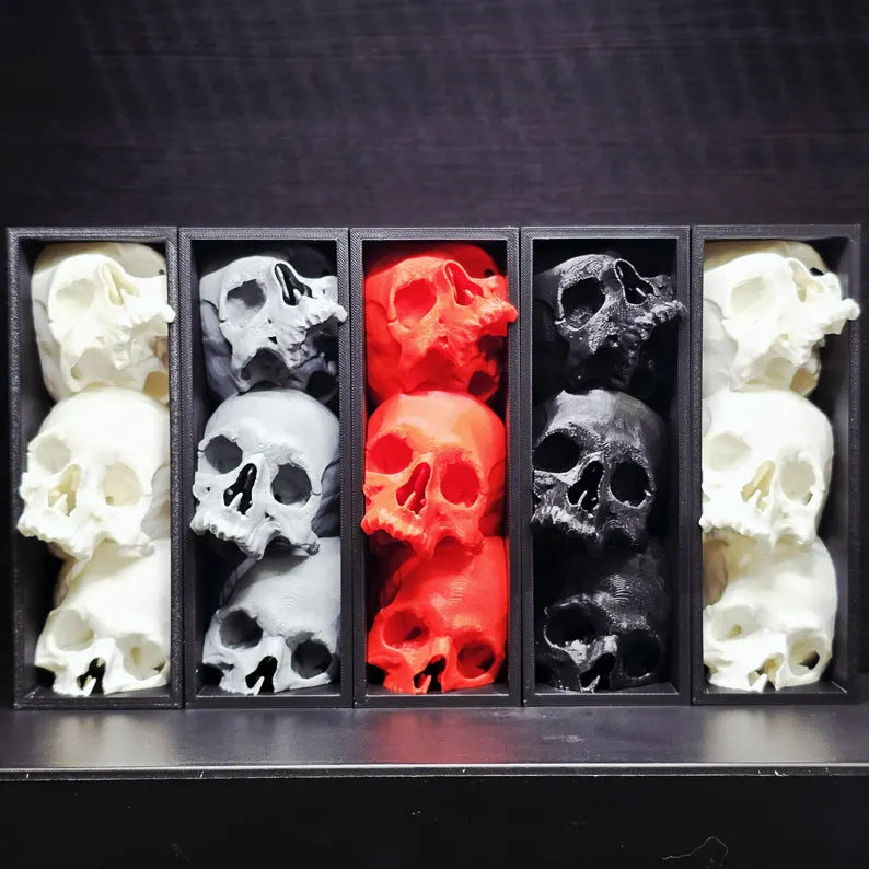 Stacked skull shelf accent, three cast skulls in a matte black frame, five colorways shown