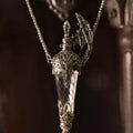 Winged glass vial pendant with dark filigree cap, full chain view