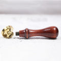 Vintage brass wax seal stamp with beech wood handle on a light background