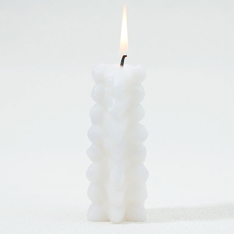 Vertebral Votive spine candle lit with wax melting down the column