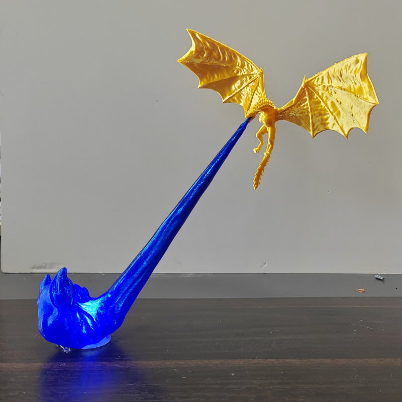 Gold 3D-printed dragon riding a glowing blue LED flame column, displayed on a desk