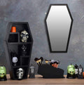 Black coffin-shaped wall shelf displaying crystals and candles, gothic home decor